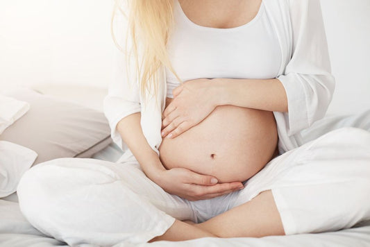 women sitting and holding her pregnant belly