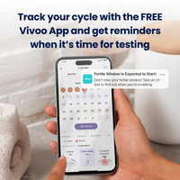 Person holding a smartphone displaying the Vivoo app with text about tracking cycles and receiving reminders.