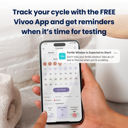 Person holding a smartphone displaying the Vivoo app with text about tracking cycles and receiving reminders.