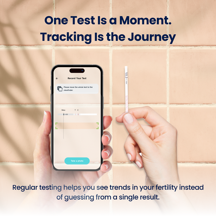 Hand holding a smartphone with Vivoo App and a test strip on a tiled background.