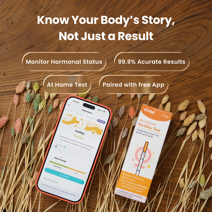 At-home fertility test kit with Vivoo App on a wooden surface with dried plants.