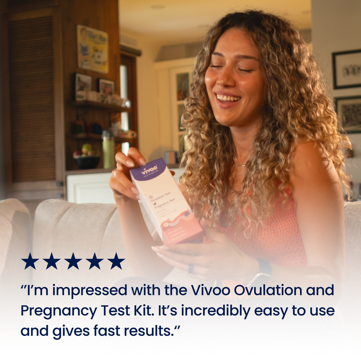 Woman holding a Vivoo Ovulation & Pregnancy Test in a living room.