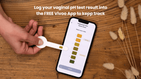Vaginal pH test with smartphone app on wooden surface