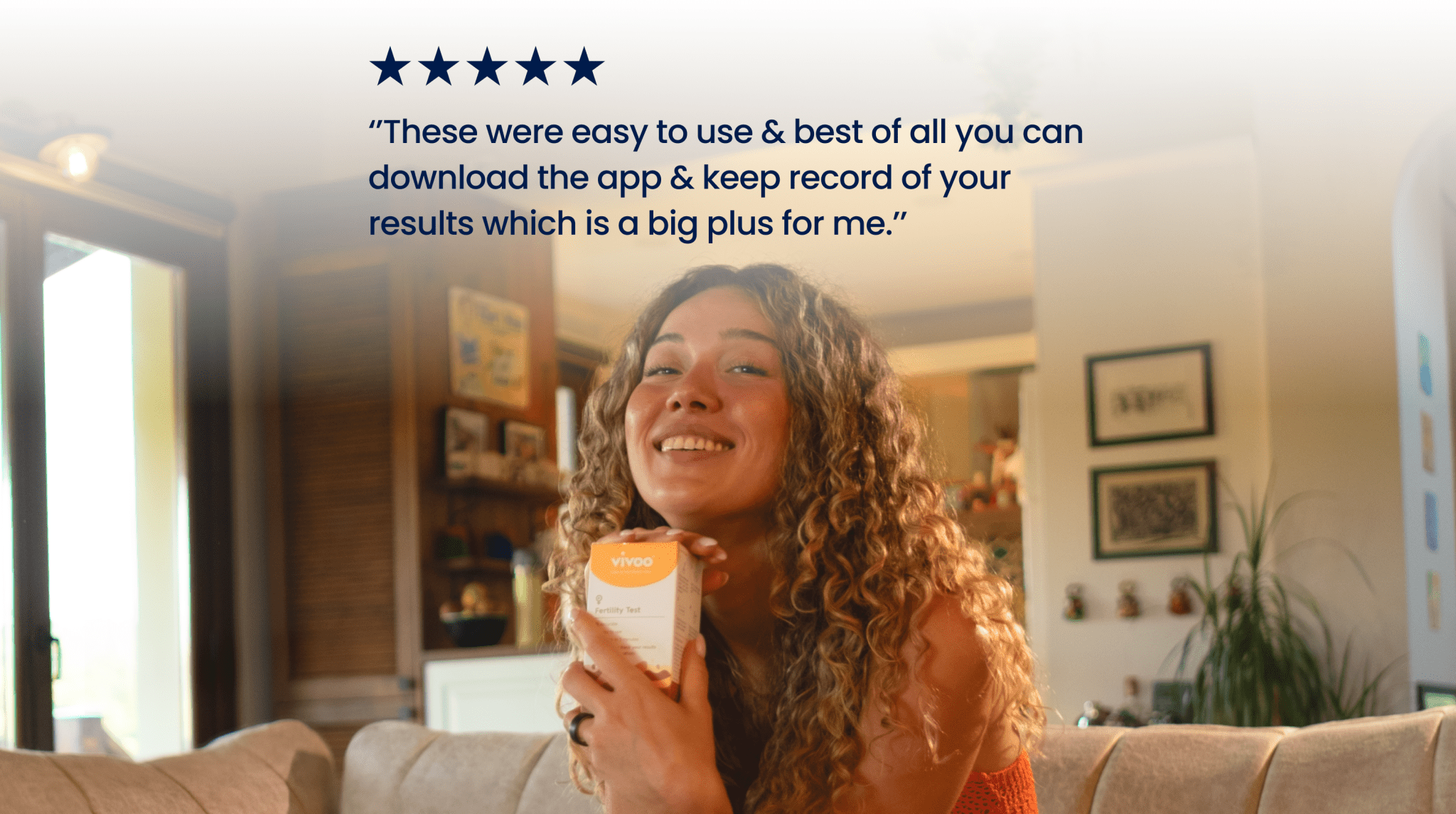 Woman holding Vivoo Fertility Test with text about an app on a blurred background