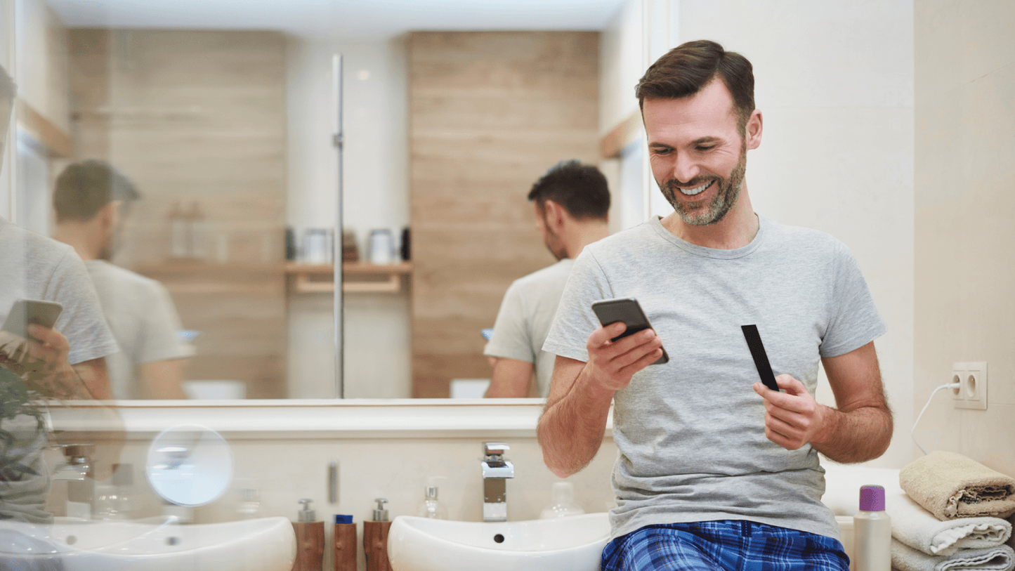 Man using a smartphone in a bathroom