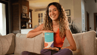 Woman holding a box labeled 'Vivoo' in a living room setting